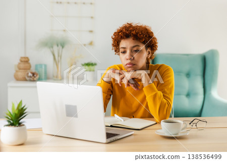 Sleepy sad African American woman sitting at table with laptop. Tired overworked girl lazy to work. Student businesswoman relaxing bored in home office after work on laptop computer 138536499
