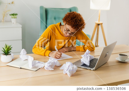 Serious African woman with crumpled paper having problem writing by hand document studying learning at home. Girl no idea sitting at workplace writing notes at office. Start up business deadline Serious African woman with crumpled paper having problem writing by hand document studying learning at home. Girl no idea sitting at workplace writing notes at office. Start up business deadline 138536506