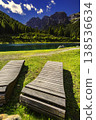 Mountain lake with wooden loungers and dramatic alpine peaks 138536634