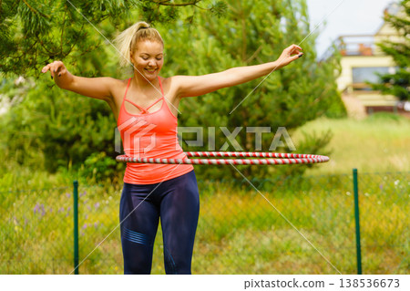Young woman with hoola hoop outdoors Young woman with hoola hoop outdoors 138536673