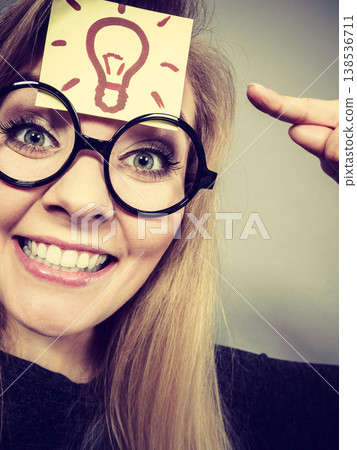 Woman having light bulb mark on forehead thinking Woman having light bulb mark on forehead thinking 138536711