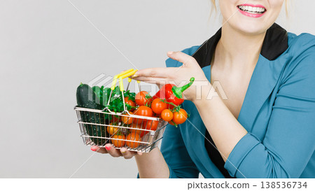 Woman holds shopping basket with vegetables 138536734