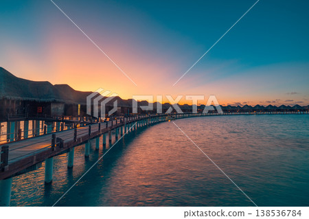 Gorgeous dreamy pier with overwater villas and radiant sunset ocean reflection, majestic luxury tropical tourism scenic background 138536784