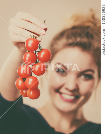 Woman holding fresh cherry tomatoes Woman holding fresh cherry tomatoes 138536928