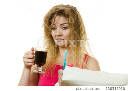 Tired woman holding toothbrush and coffee Tired woman holding toothbrush and coffee 138536930