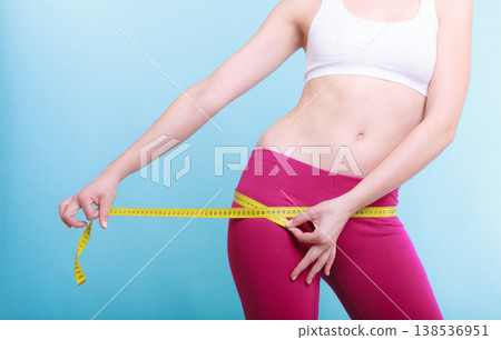 Fitness woman fit girl with measure tape measuring her loins 138536951