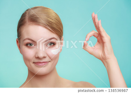 woman applying cream on her skin face. 138536987