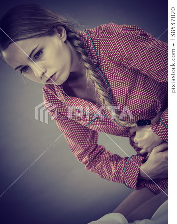 Sad young teenager woman on bed feeling pain 138537020