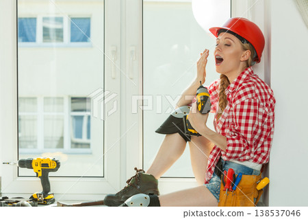 Bored woman with helmet next to the window Bored woman with helmet next to the window 138537046