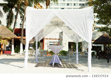 White wedding canopy with chandelier on beach White wedding canopy with chandelier on beach 138537414