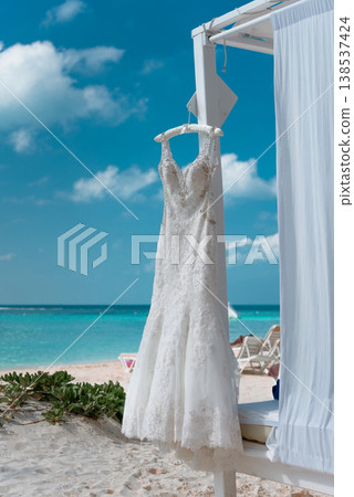 Wedding dress on beach cabana with turquoise ocean view Wedding dress on beach cabana with turquoise ocean view 138537424