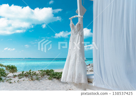 Wedding dress on beach cabana with turquoise ocean view Wedding dress on beach cabana with turquoise ocean view 138537425