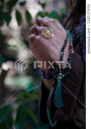 Woman hands with gold ring and turquoise beaded necklace Woman hands with gold ring and turquoise beaded necklace 138537450