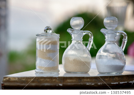 Decorative glass containers with layered sand on outdoor table Decorative glass containers with layered sand on outdoor table 138537495