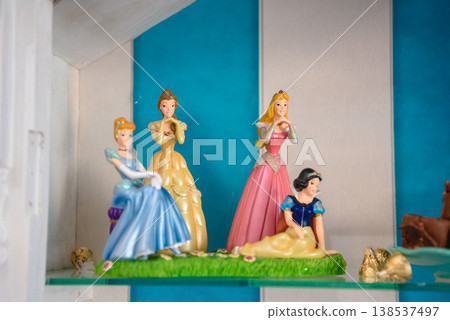 Colorful princess figurines displayed on turquoise shelf Colorful princess figurines displayed on turquoise shelf 138537497