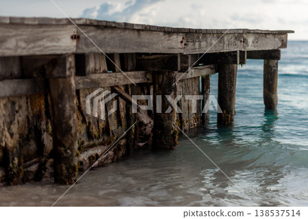 Weathered wooden pier structure over turquoise ocean water Weathered wooden pier structure over turquoise ocean water 138537514