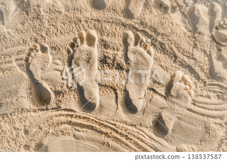 Family footprints with wedding rings in beach sand Family footprints with wedding rings in beach sand 138537587