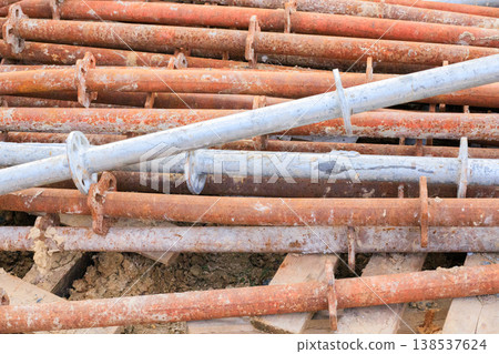 Industrial metal supports with flanges showing signs of heavy use and oxidation, stored outdoors. Industrial metal supports with flanges showing signs of heavy use and oxidation, stored outdoors. 138537624