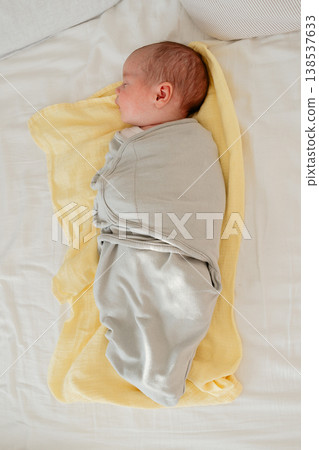 Newborn baby sleeping peacefully on a soft yellow blanket at home. Cozy natural light, calm atmosphere and tender early childhood moment. Concept of parenting and newborn care. Newborn baby sleeping peacefully on a soft yellow blanket at home. Cozy natural light, calm atmosphere and tender early childhood moment. Concept of parenting and newborn care. 138537633