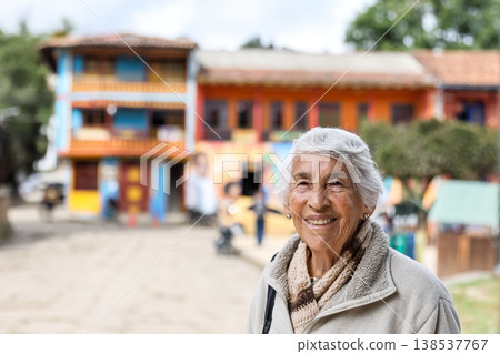 Happy senior lifestyle concept. Senior woman at the central square of the beautiful small town of Raquira. The city of pots in Colombia. 138537767