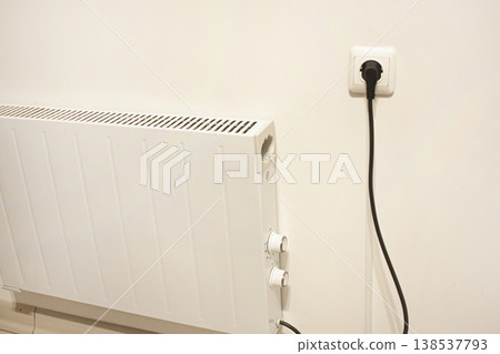 Storage Heater, Electric heater on white wall plugged into socket Storage Heater, Electric heater on white wall plugged into socket 138537793