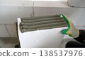 Worker applying glue adhesive on aerated concrete block at construction site. 138537976