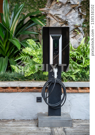 Hi-tech charging station with electronic display arranged on street for electric vehicle EV car. 138538102