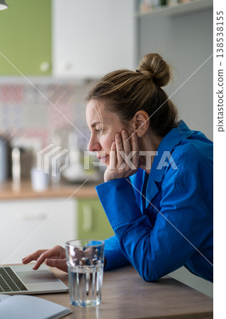 Curious positive woman shopping online on laptop, looking through content, choosing best offers. Curious positive woman shopping online on laptop, looking through content, choosing best offers. 138538155