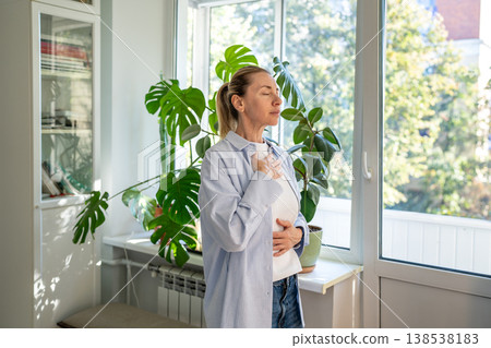 Calm woman practicing deep breathing in daily stress relief and mindfulness training at home. Calm woman practicing deep breathing in daily stress relief and mindfulness training at home. 138538183