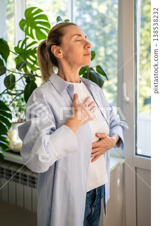Mindful woman with hands on chest and abdomen practicing deep breathing anti-stress exercise. 138538232