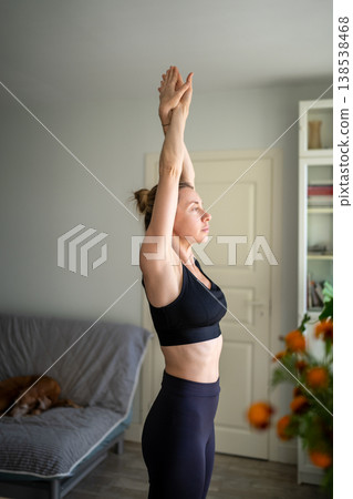 Calm mature woman practicing fitness exercises workout for mental health and stress relief at home. Calm mature woman practicing fitness exercises workout for mental health and stress relief at home. 138538468