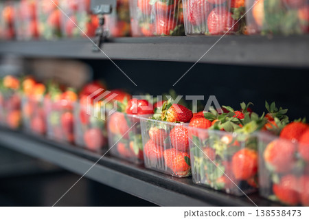 Red organic strawberries grown at smart farm packed in plastic boxes displayed on shelf in storage. Red organic strawberries grown at smart farm packed in plastic boxes displayed on shelf in storage. 138538473