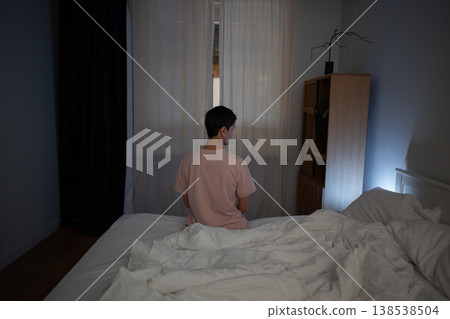 Sleepless senior woman sitting in bed late at night looking at light from smartphone screen. Sleepless senior woman sitting in bed late at night looking at light from smartphone screen. 138538504
