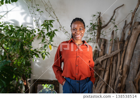 Positive confident African American woman posing in home garden with smiling optimistic expression. Positive confident African American woman posing in home garden with smiling optimistic expression. 138538514