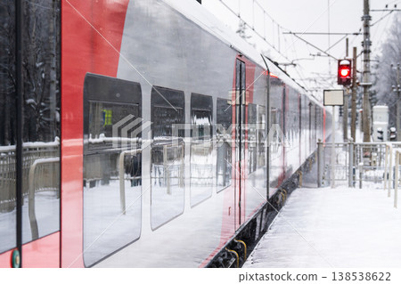 Modern high-speed electric train arriving at railway station platform at high speed on winter day Modern high-speed electric train arriving at railway station platform at high speed on winter day 138538622