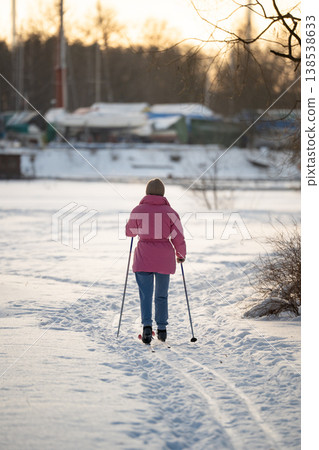 Woman spending free time on weekend skiing in public city park, keeping physical activity in winter. Woman spending free time on weekend skiing in public city park, keeping physical activity in winter. 138538633