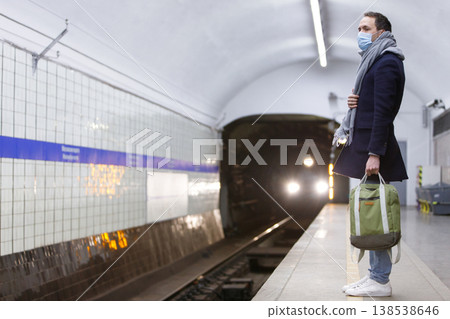 man wearing protective mask, waiting train at subway station. man wearing protective mask, waiting train at subway station. 138538646