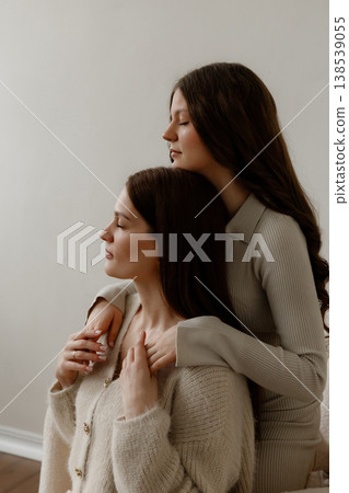 Caucasian Mother Lovingly Supporting Her Teenage Daughter In Softly Lit Studio Setting Caucasian Mother Lovingly Supporting Her Teenage Daughter In Softly Lit Studio Setting 138539055