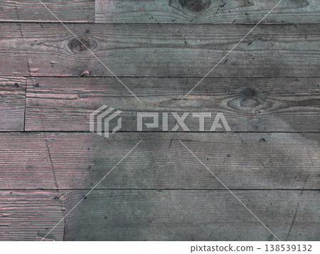 Weathered wood planks forming a rustic surface texture with visible grain patterns and knots, perfect for backgrounds, flooring, and natural design elements. 138539132