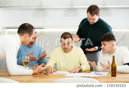 Group of men supporting troubled friend reading legal notice Group of men supporting troubled friend reading legal notice 138539163