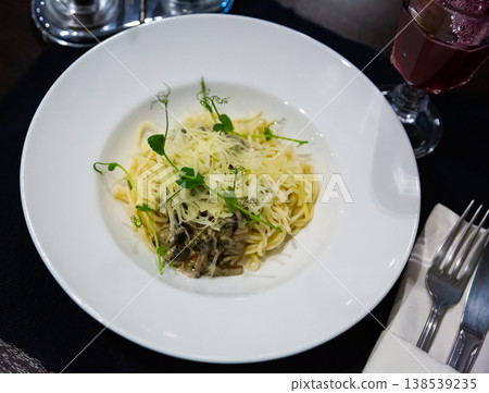 Pasta with portobello mushrooms in creamy sauce, cheese, greens Pasta with portobello mushrooms in creamy sauce, cheese, greens 138539235