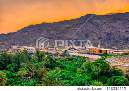 A beautiful sunset over the mountains and lush palm groves surrounding Thee Ain village in the Al Bahah region of Saudi Arabia. 138539335