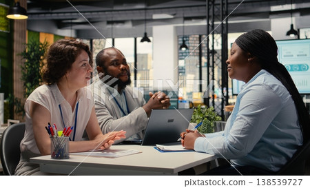 Black woman candidate signing contract during interview with HR team, filling the new organization position after the selection process. Hiring a person with commitment. Camera A. Black woman candidate signing contract during interview with HR team, filling the new organization position after the selection process. Hiring a person with commitment. Camera A. 138539727