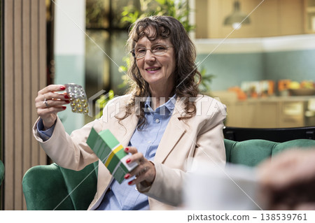 Retired woman taking pills from vial for daily wellness routine, including prescribed medication and probiotics focused on disease management and prevention. Wellbeing during retirement age. Retired woman taking pills from vial for daily wellness routine, including prescribed medication and probiotics focused on disease management and prevention. Wellbeing during retirement age. 138539761