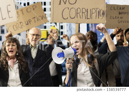 Gen z girl attends public protest with people marching against corruption and bad governing, raising signs for freedom and equality. Spreading awareness through serious political activism. Gen z girl attends public protest with people marching against corruption and bad governing, raising signs for freedom and equality. Spreading awareness through serious political activism. 138539777