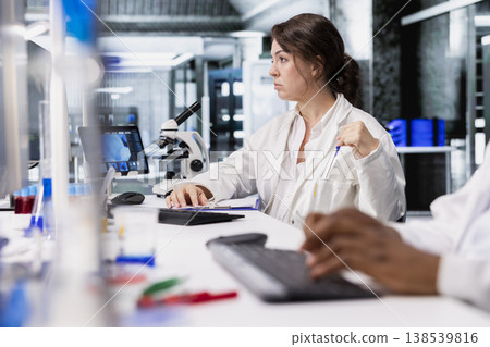 Diagnostic laboratory manager using PC, looking at 3D molecular model. Research facility specialist using bioengineering program on computer in medical lab displaying DNA data Diagnostic laboratory manager using PC, looking at 3D molecular model. Research facility specialist using bioengineering program on computer in medical lab displaying DNA data 138539816
