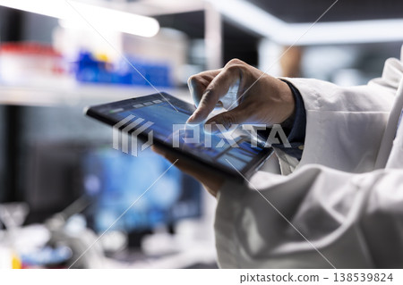 Close up of tablet running laboratory experiments in chemistry and biology. Healthcare technology and medical research data highlight advanced research in diagnostics and pharmacology. Close up of tablet running laboratory experiments in chemistry and biology. Healthcare technology and medical research data highlight advanced research in diagnostics and pharmacology. 138539824