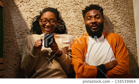 Top down view of black couple laying on the floor and enjoying peaceful time, positive ambiance with relaxation and laughter. Man and woman having fun and joking around together, domestic life. Top down view of black couple laying on the floor and enjoying peaceful time, positive ambiance with relaxation and laughter. Man and woman having fun and joking around together, domestic life. 138539864