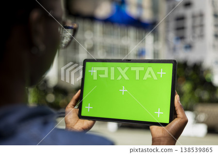 Woman using isolated screen tablet in city, relaxing by looking at social media posts on touchscreen display. Girl using mockup device to browse internet content, urban landscape background, close up Woman using isolated screen tablet in city, relaxing by looking at social media posts on touchscreen display. Girl using mockup device to browse internet content, urban landscape background, close up 138539865