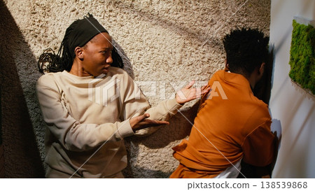 Top down view of black couple in conflict expressing displeasure and emotional frustration, sitting on carpet in the hallway. Unhappy people depicting toxic relationship, domestic life emotions. Top down view of black couple in conflict expressing displeasure and emotional frustration, sitting on carpet in the hallway. Unhappy people depicting toxic relationship, domestic life emotions. 138539868